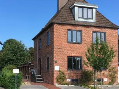 Außenansicht der Praxis in Holtenau: Backsteinhaus mit Eingangstreppe